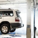 Biały SUV terenowy na podnośniku w warsztacie podczas przeglądu