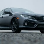 Honda Civic zaparkowany w lekkiej mgle na pustym parkingu
