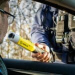 Policjant sprawdza trzeźwość kierowcy alkomatem podczas kontroli drogowej