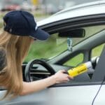 Policjantka drogówki przeprowadza badanie alkomatem kierowcy
