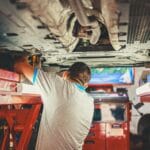 Mechanik podniesionego auta podczas przeglądu w warsztacie samochodowym