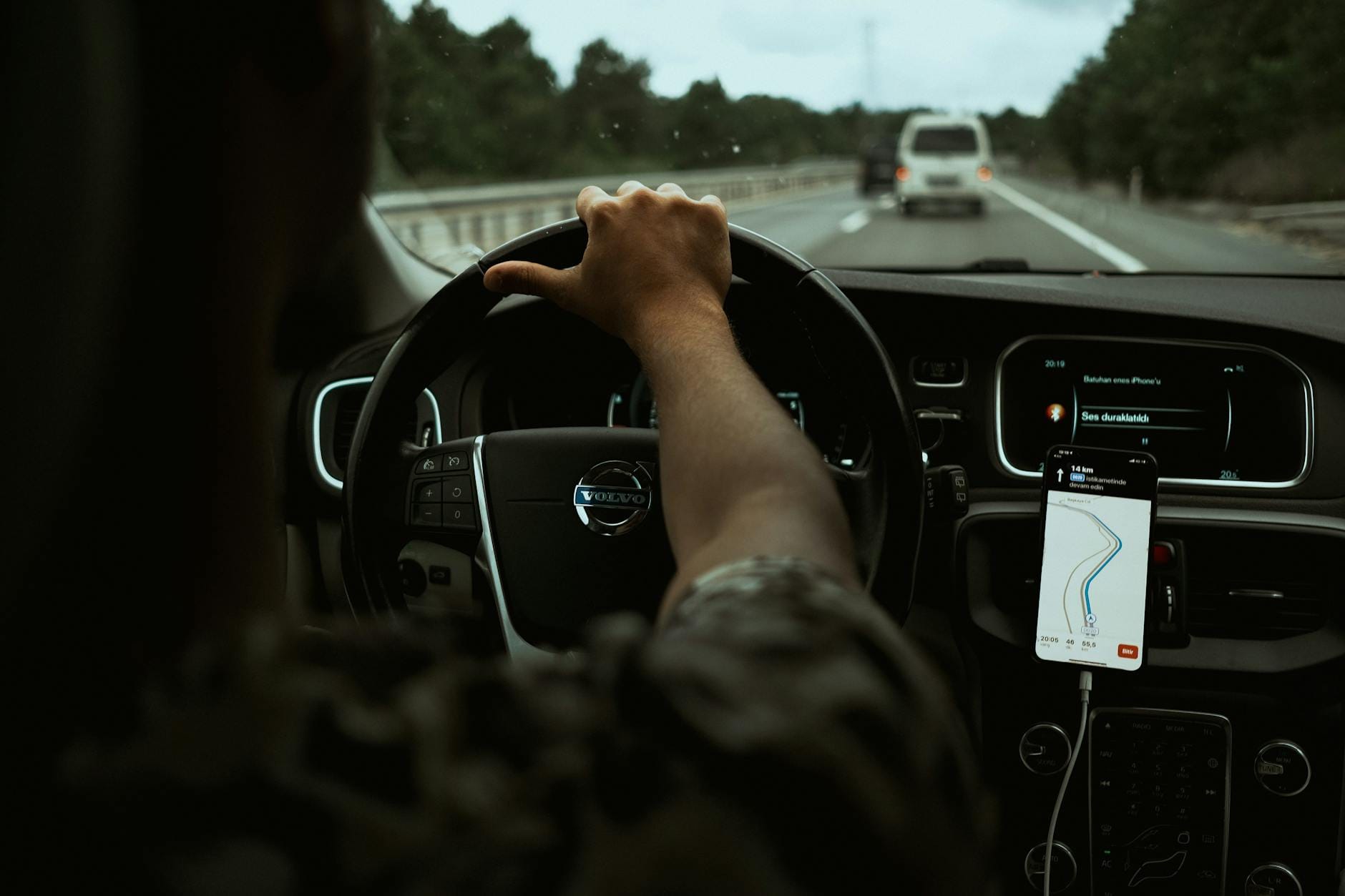 Kierowca korzysta z nawigacji GPS w smartfonie we wnętrzu nowoczesnego auta