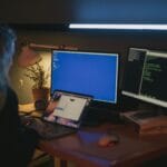 Kobieta przy biurku w domowym biurze pracuje nad cyberbezpieczeństwem
