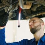 Mechanik serwisuje samochód na podnośniku w warsztacie po zakupie z leasingu