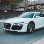 Nowoczesne auto premium jedzie wąską ulicą miasta o zmierzchu