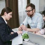 Para omawia dokumenty finansowe z doradcą przy biurku