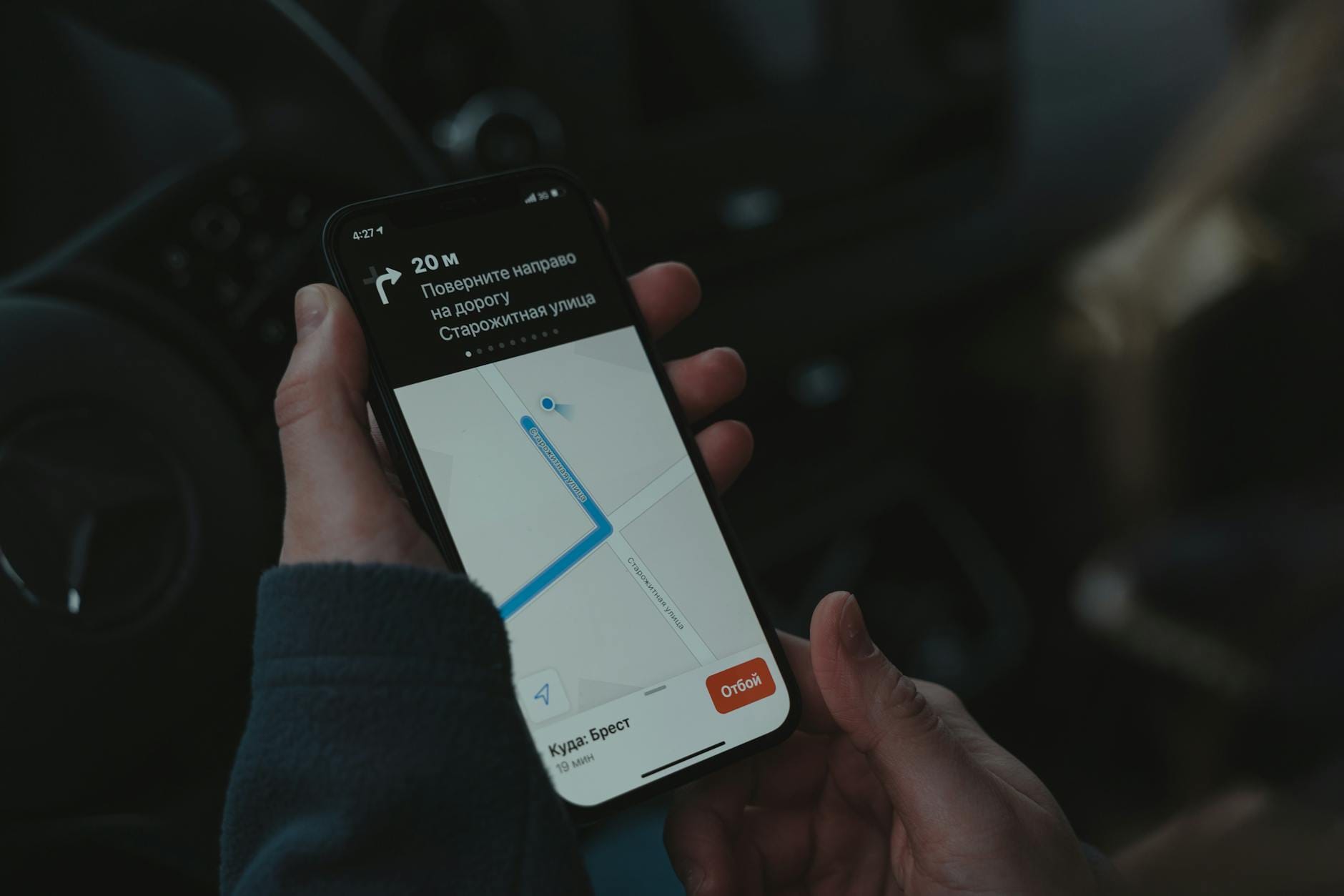 Smartfon z uruchomioną nawigacją samochodową na desce rozdzielczej